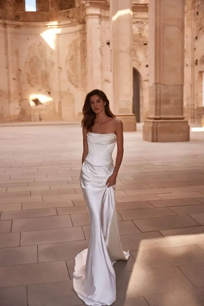 model is wearing a strapless fitted floor length bridal gown