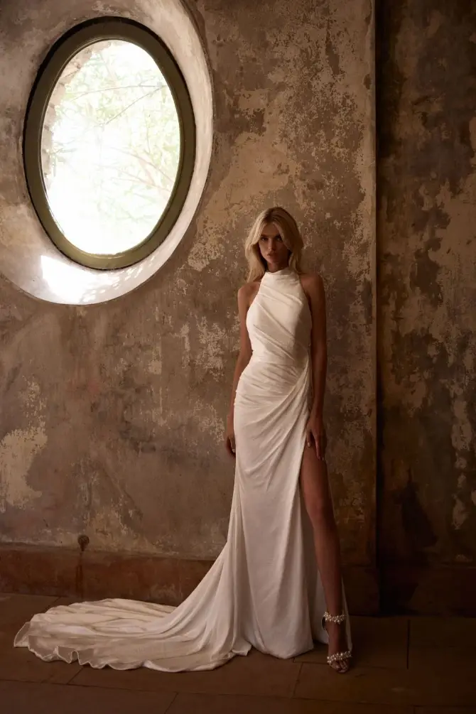 model is wearing a high neck sleeveless fitted wedding dress