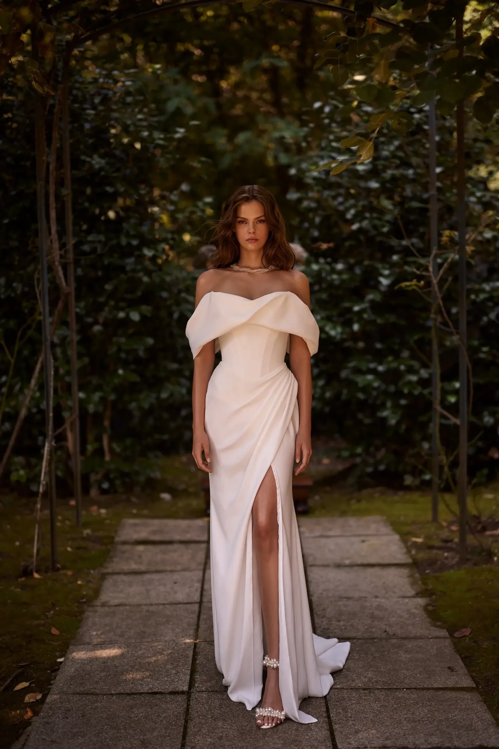 model is wearing a drapey off the shoulder a-line wedding dress