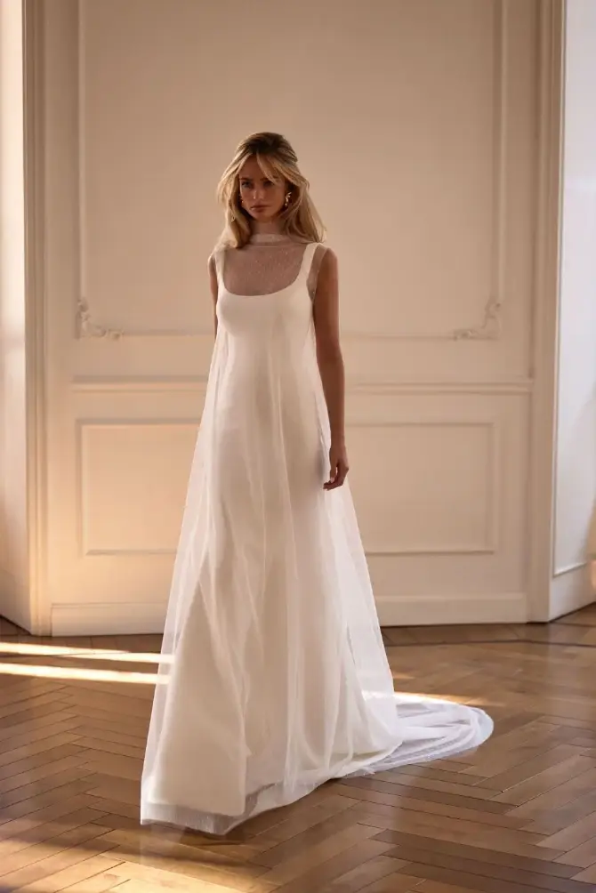 model is wearing a flowy sleeveless a-line wedding dress