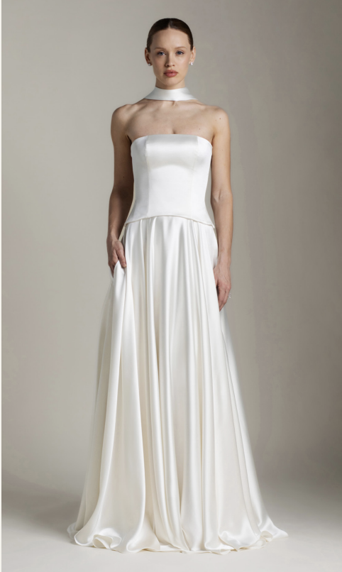 A model wearing a strapless white gown with a flowing skirt.