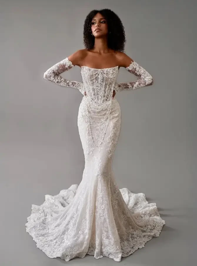 Model is wearing a strapless fit and flare lace bridal gown 