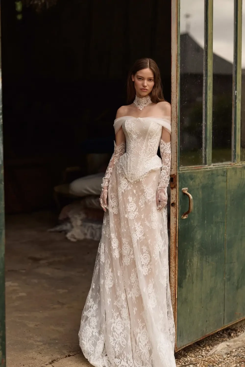 model is wearing an off the shoulder vintage inspired bridal gown
